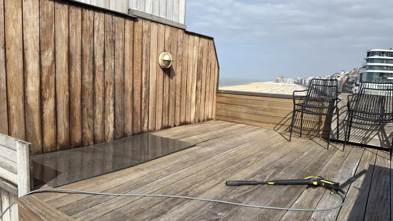 Reiniging van het houten dek van een dakterras.